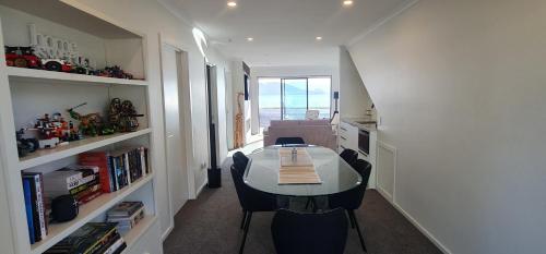a small room with a table and chairs and a kitchen at Kakianau Retreat, Luxury Waterfront Apartments in Portobello