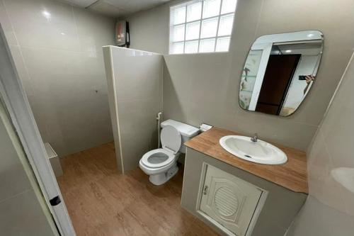 a bathroom with a toilet and a sink and a mirror at Sakun Place in Bangna