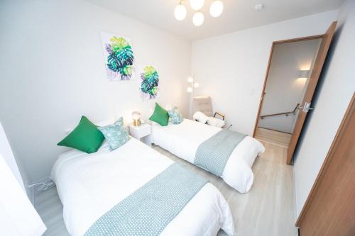 two beds in a room with a mirror at Nagashima Riverside Resort 5 in Kuwana