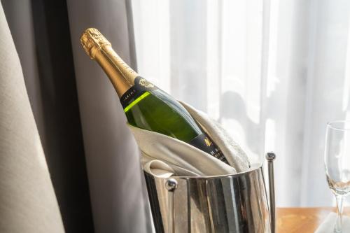 a bottle of champagne in a bucket on a table at Hotel Boutique Casa del Jardín Aguascalientes in Aguascalientes
