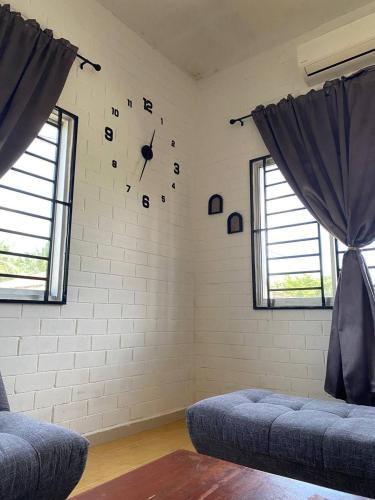 a room with a brick wall with a clock on the wall at Brickhouse Parit Raja UTHM in Parit Raja