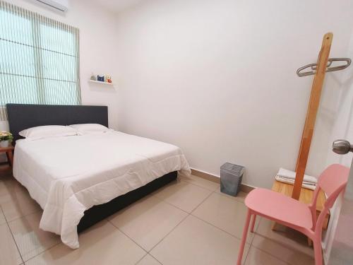 a bedroom with a white bed and a pink chair at Bayu Temiang Luxury Design 7~8 Pax in Seremban