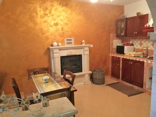 a kitchen with a table and a fireplace in a kitchen at Apartments Barbara in Poreč