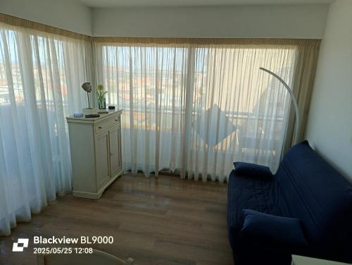 a living room with a couch and a large window at T2 Vue latérale Mer 1 Ligne clim in Canet-en-Roussillon