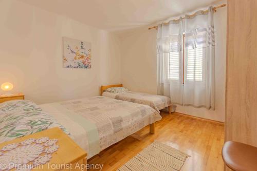 a bedroom with two beds and a window at Stanko in Kustići