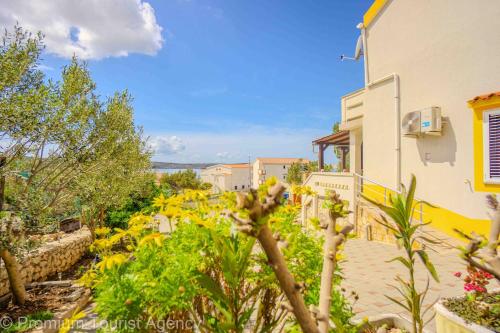 a garden with yellow flowers in front of a house at Stanko in Kustići