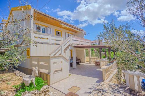 a house with a staircase leading to a patio at Stanko in Kustići