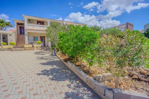 a house with a brick driveway and trees in front of it at Stanko in Kustići