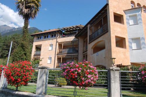 a building with flowers on a fence and a palm tree at Apartmenthaus am Waalweg in Caines