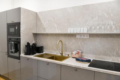 a kitchen with a sink and a microwave at Alexander library apartment in Košice
