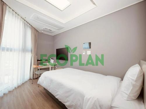 a bedroom with a white bed and a green sign on the wall at Sollago Myeongdong Hotel & Residence in Seoul