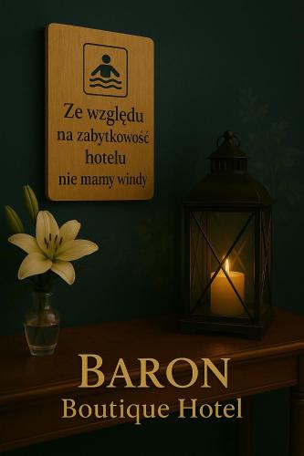 a lantern on a table with a sign and a flower at Baron Boutique Hotel in Jelenia Góra