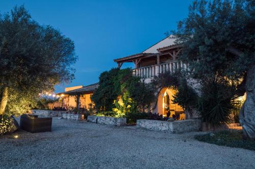 a home at night with a gravel driveway at Casa di Melo - Organic Country Hotel in Cassibile