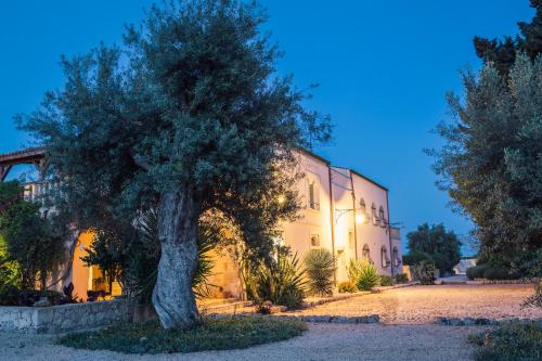 a tree sits in front of a building at Casa di Melo - Organic Country Hotel in Cassibile