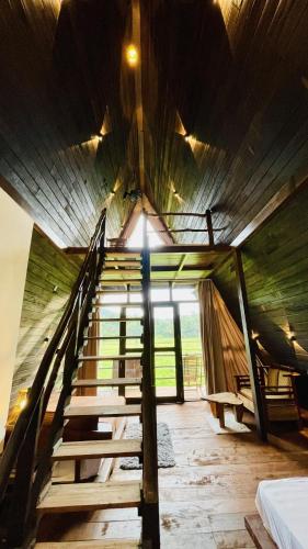 a staircase in a room with a wooden ceiling at The wilds Sinharaja in Deniyaya