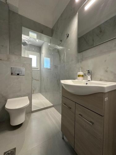 a bathroom with a sink and a toilet and a shower at Vista Verde Apartments in Sidari