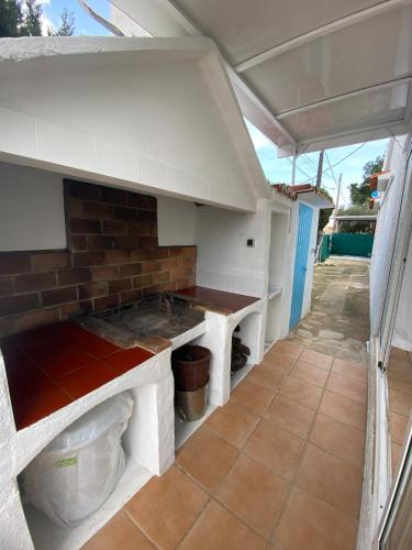 a kitchen with white cabinets and a brick wall at Terreta de Denia in Denia