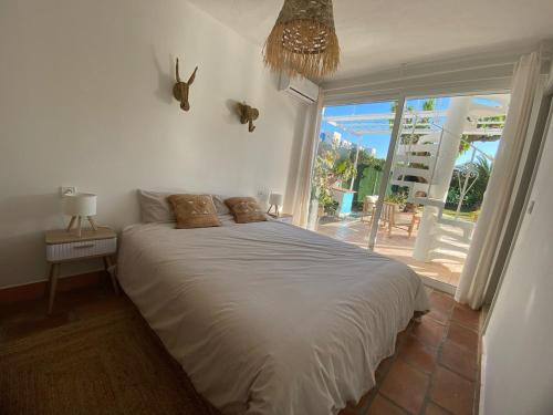 a bedroom with a bed and a large window at Terreta de Denia in Denia