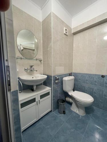 a bathroom with a toilet and a sink and a mirror at Guest rooms Marina in Obzor