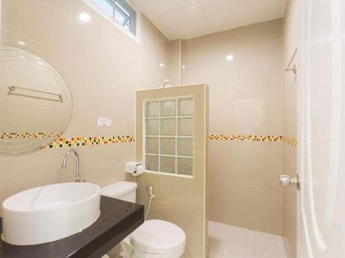 une salle de bain avec un lavabo, des toilettes et une douche dans l'établissement Holland Resort Phuket, à Ban Phlu Yai
