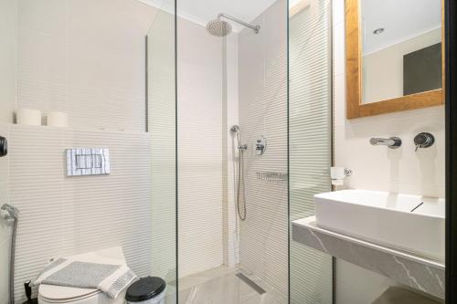 a bathroom with a glass shower and a sink at Gorgona Hotel in Amoudara Herakliou