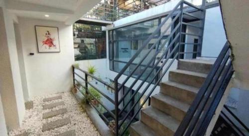 a staircase in a house with a glass railing at Dali Four Seasons Hostel in Dali Ancient Town