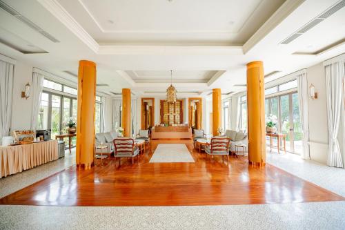 a large living room with wooden floors and windows at THE NAVY HOUSE HOTEL in Sattahip