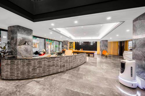 an office lobby with a reception desk and a couch at Atour S Hotel Chengdu Taikoo Li in Chengdu