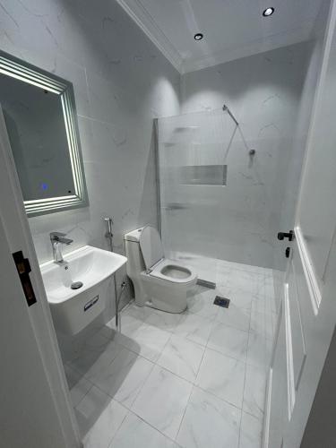 a white bathroom with a toilet and a sink at غرفة وصالة بنظام فندقي مميز in Jeddah