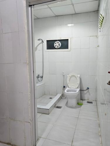 a bathroom with a toilet and a shower and a tub at Farm N# 200 divan area in Al Khatim
