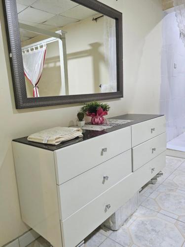 a bathroom with a white dresser with a mirror at Farm N# 200 divan area in Al Khatim