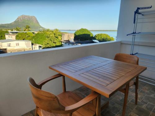 a table and chairs on a balcony with a view of the ocean at AA Sea-view and Mountain view Apartment in La Gaulette