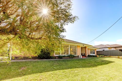 a house with a tree in the yard at Emu Point Beach Cottages - by the BnB Collection in Emu Point