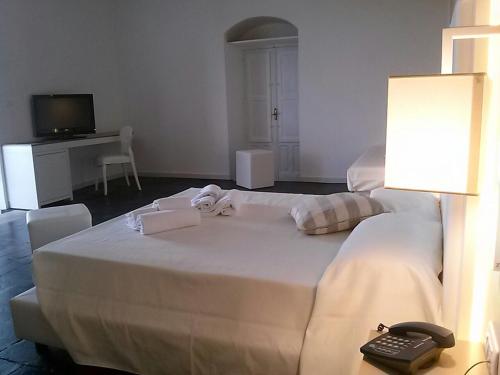 a hotel room with a bed with a phone on it at Villa Principe Di Belmonte in Ispica