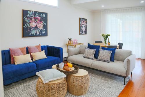 a living room with a blue couch and two couches at Escape to a timeless getaway in Provincial Vic in Ballarat