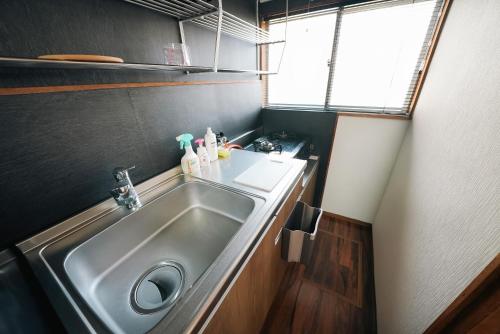 a small kitchen with a sink and a window at Takumi Renovated House Osaka Hirakata with Free Parking in Hirakata
