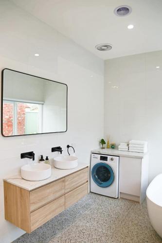 a bathroom with two sinks and a washing machine at Escape to a timeless getaway in Provincial Vic in Ballarat