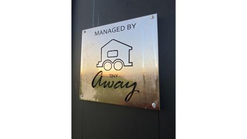 a sign on a door that readsmanaged by my always at Tiny Charm by Tiny Away in Lake Charm