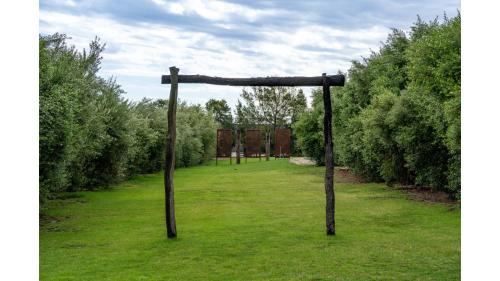 a wooden pole in a field of grass at Tiny Charm by Tiny Away in Lake Charm