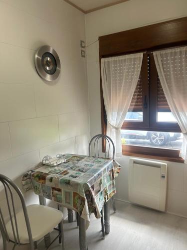 a room with a table and chairs and a window at EL HOGARIN DE ARRIONDAS in Arriondas