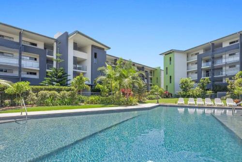 a swimming pool in front of some apartment buildings at Broadwater on the Peninsula in Kawana Waters