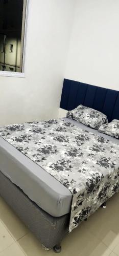 a bed with a black and white blanket on it at Apto novíssimo prox Alphaville e ginásio barueri in Jandira