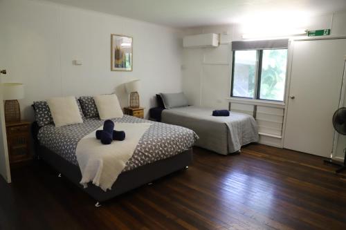 a bedroom with two beds and a couch and a window at Mt Bundy Station in Adelaide River