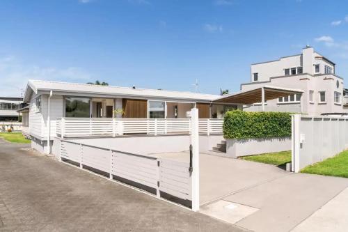 a white fence in front of a house at Peaceful Oasis near the Beach and Mount Mainstreet Shopping Centre in Mount Maunganui