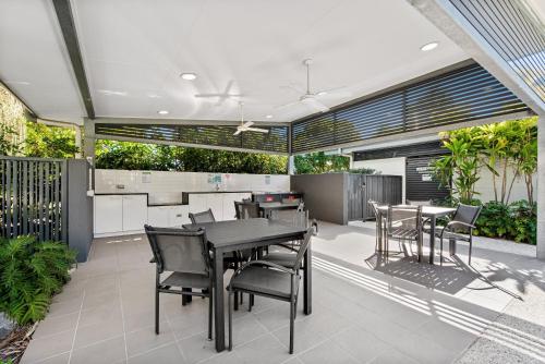 an outdoor dining area with tables and chairs at Broadwater on the Peninsula in Kawana Waters