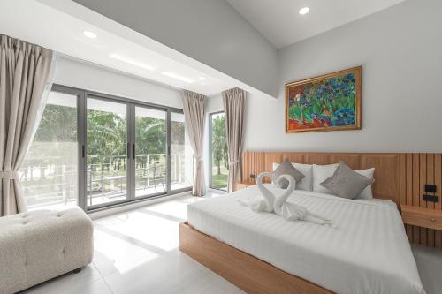 een slaapkamer met een bed met twee zwanen erop bij V192 Brand New Golf side 5BR Villa with Private Pool in Ban Kathu (1)