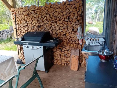 a stove and a pile of wood next to a wall at Boheemlaslik pööning Pädaste lahe ääres in Pädaste