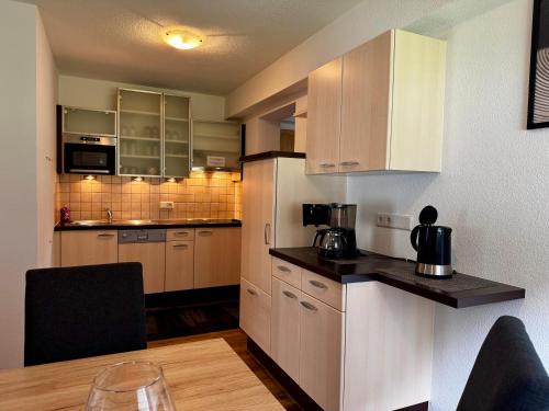 una cucina con mobili bianchi e un tavolo in una stanza di Apart Kofler a Längenfeld