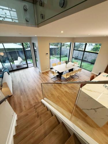 a large living room with a table and chairs at Brand-New Luxury 5 bedroom house in Epsom in Auckland