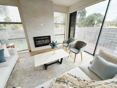 a living room with a couch and a fireplace at Brand-New Luxury 5 bedroom house in Epsom in Auckland